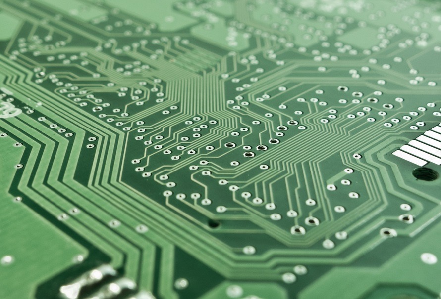 Close-up of a green printed circuit board with copper traces and solder points